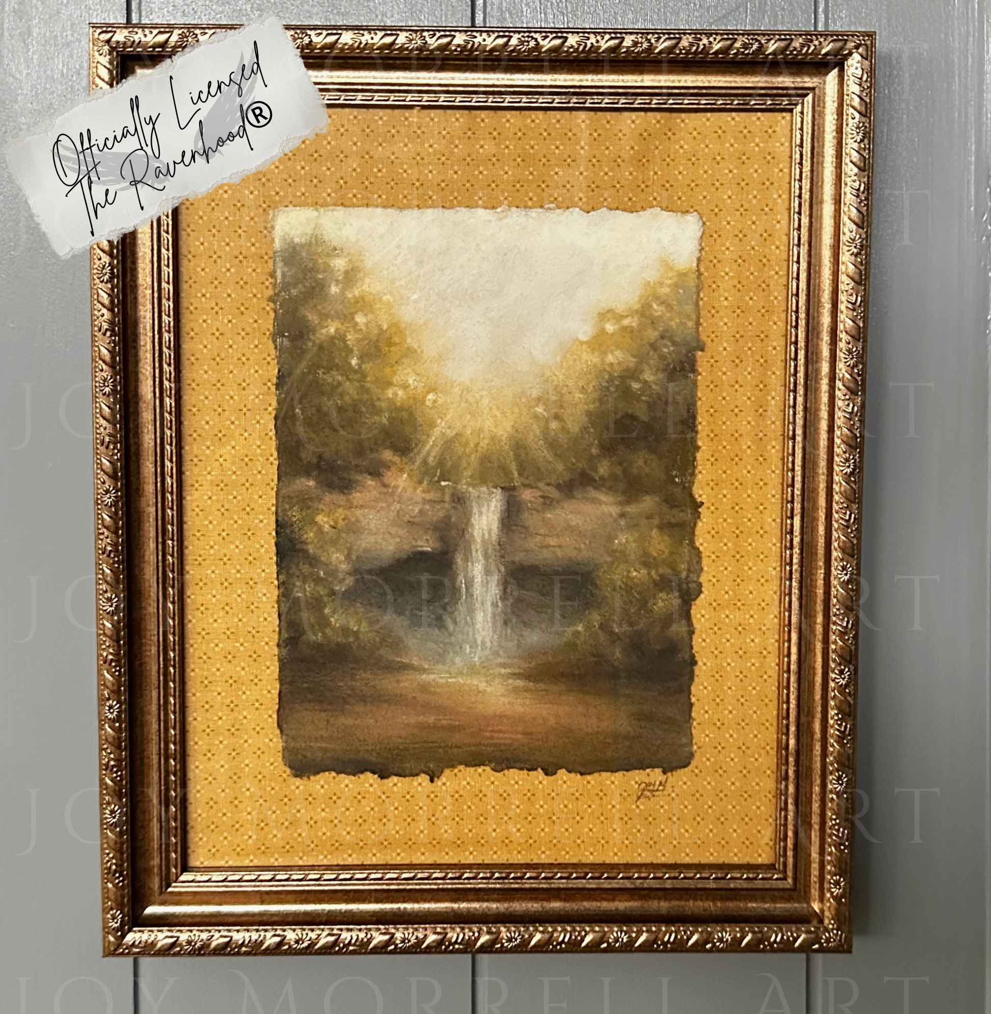 Framed artwork of a waterfall on a textured gold background